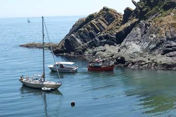 Fishing boats and leisure craft wait for the tide to rise to go into the harbour.