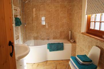 The large family bathroom has a large bath and fitted shower and plenty of room to dry off.