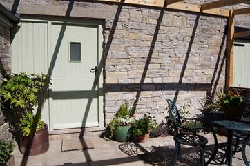 The pretty sitting-out area beneath the pergola catches the afternoon and evening sun.