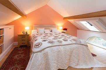 The bedroom is in the mezzanine-area - a lovely space with bespoke shutters and a very clever storage solution.