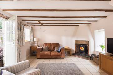 The sitting-room with comfy sofa, chair and the cosy wood-burner.
