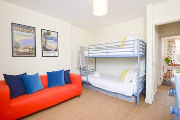 The bunk room has a sofa and a TV.