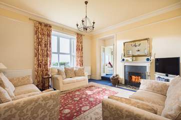 The sitting-room with comfy sofas around the fire.
