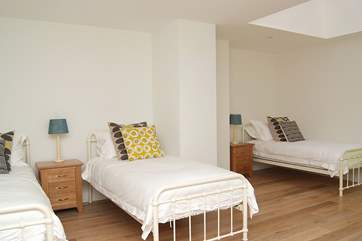 Bedroom 2 is spacious and furnished with three single beds.