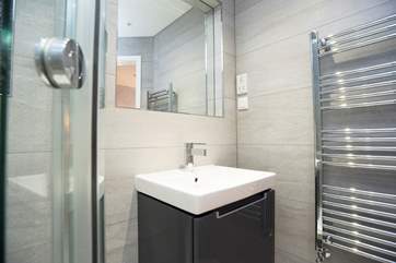 A wall-hung wash-basin sits below the de-mist mirror.