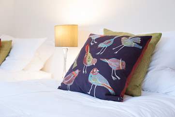 A range of fabrics and soft furnishings in purples and greens can be found throughout the apartment.