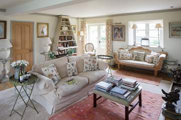 The elegant drawing room has French windows that open out onto the garden at the back of the farmhouse.