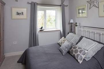 Bedroom 3 has a double bed, pretty feature fireplace, and views of the garden and the orchard; the shower room is just next door.