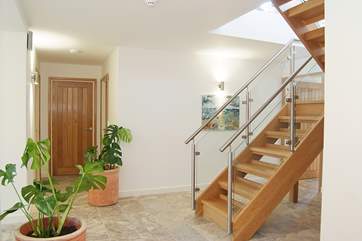 The entrance hallway with an oak and glass staircase.