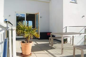 The sheltered patio outside the kitchen-area catches the afternoon and evening sun, perfect for drinks and meals on balmy evenings.