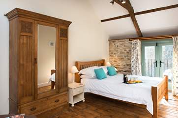 The second bedroom is equally delightful and the sunlight streams through the French doors.
