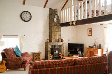 The spacious sitting-room with vaulted ceiling and galleried sitting-area with a view from the balcony across to the estuary.
