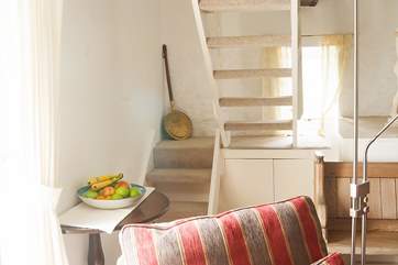 The narrow wooden staircase leads up to the galleried sitting-area.