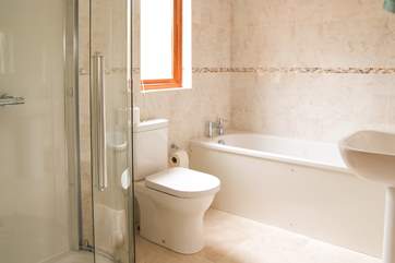 The bathroom has both a bath and shower cubicle.