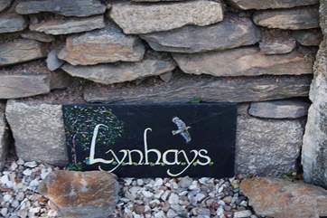 The name sign to the left of the front gate
.