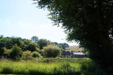 Looking across the river to an old cottage and barns on the other side.