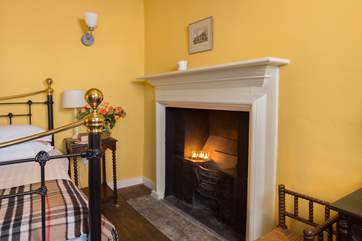 The original fireplace is a lovely ornamental feature in this bedroom.
