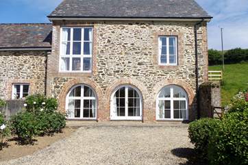 The master bedroom has the three ground floor windows, the open plan living area and kitchen are above and to the left-hand side of this building encompasses the entrance hall and second bedroom.
