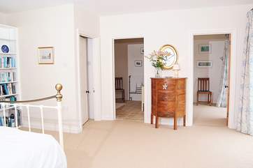 At the far end of this spacious bedroom is an en suite bathroom and a separate dressing-room or cot-room.