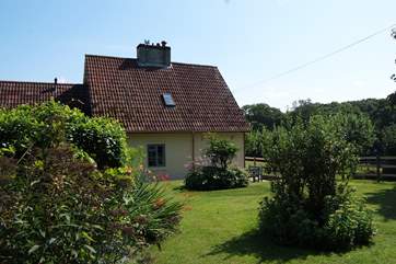 The cottage is set to one side of its gardens and has lovely views across the fields.