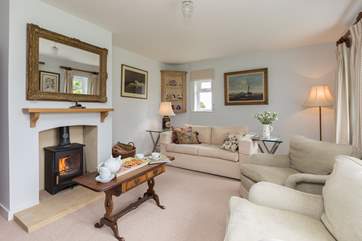 The calm and elegant living room has a wood burning stove for out of season holidays. This dual aspect room looks out over the fields.