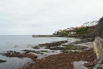 High tide down in the harbour hides the sandy beach revealed as the tide drops down.