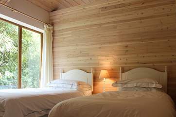 The twin bedroom with 3ft single beds and open roof up to the wooden beams above.