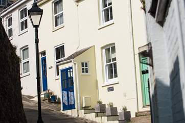 Whistlefish (house with porch and blue door) is one of a terrace of four cottages on a very steep pedestrian hill.