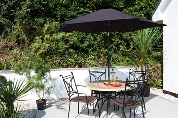 The sunny patio is approached by a flight of stone steps.