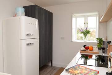 The compact kitchen is at one end of the open plan space.