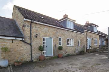 Barn Owls Cottage from the farmyard, nestled between the two other cottages that were originally one very long stone barn.