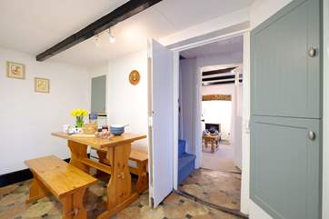 Looking from the kitchen through to the sitting-room, with steep cottage stairs leading to the first floor.