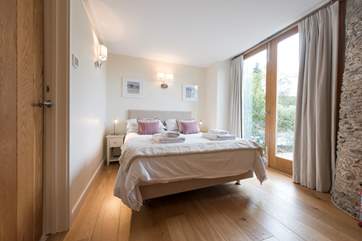 Bedroom 1 has balcony doors which lead out onto the sun-trap of a patio.