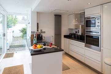 The well-equipped modern kitchen has all you need to conjur up something delicious; beyond is the downstairs shower-room.