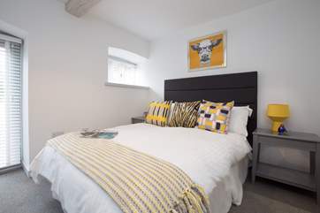 There are full length windows in this room and stylish plantation-style white blinds.