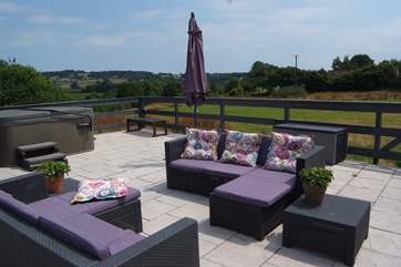 The terrace has wonderful rural views and a table and chairs as well as this relaxed seating for perfect outdoor living on a sunny day.