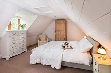 A luxurious king-sized bed is at the far end of the apartment.