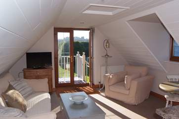 The living space has a wonderfully comfy sofa and lovely deep armchair.