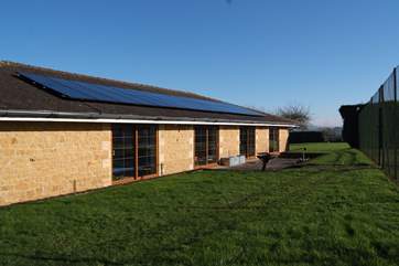 Another view of the pool room with the BBQ terrace and tennis court behind it.