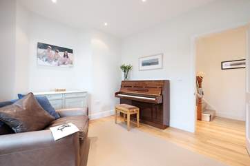 There is a piano at one end of the sitting-room.