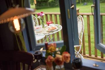Looking through the dining-area window to the deck with table and chairs for al fresco dining.