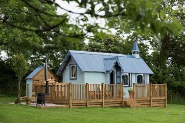 The Tabernacle at Frieda and The Moon with its hot tub settled into the corner of a meadow with beautiful views across open countryside.