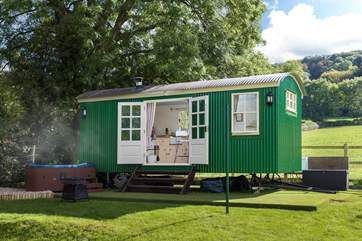 This gorgeous shepherd's hut is in a private location, sheltered by the trees behind it and with the luxury of a wonderful hot tub.