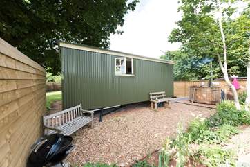 The back of the hut with another sheltered and private patio area (and barbecue) and the hot tub.