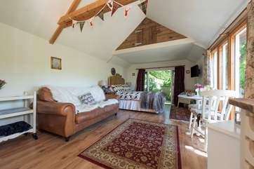 There is a comfortable sofa and this and the dining table are positioned to make the most of the view over the garden below.