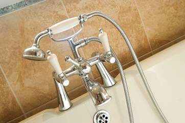 A hand held shower attachment over the claw-foot bath.