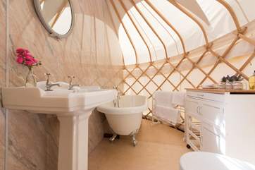 There is a free-standing roll-top bath, wash-basin and flushing toilet.