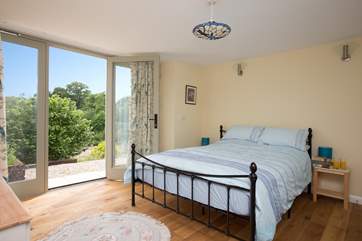 The main bedroom with its king-sized bed is on the same level as you enter the Studio. This room has French windows too - and that special view to enjoy from your bed !