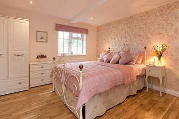 This bedroom with its king-size iron framed bed is at the far end of the property with views out over the fields that run alongside the driveway.