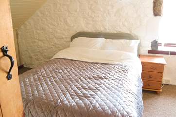 The double bedroom has lovely stone walls.